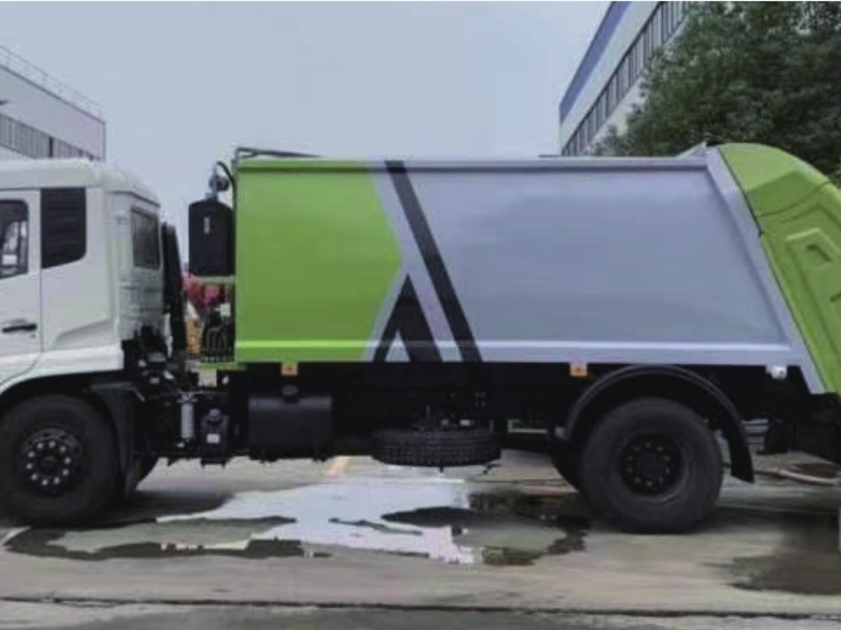 綠色壓縮式垃圾車側面實拍